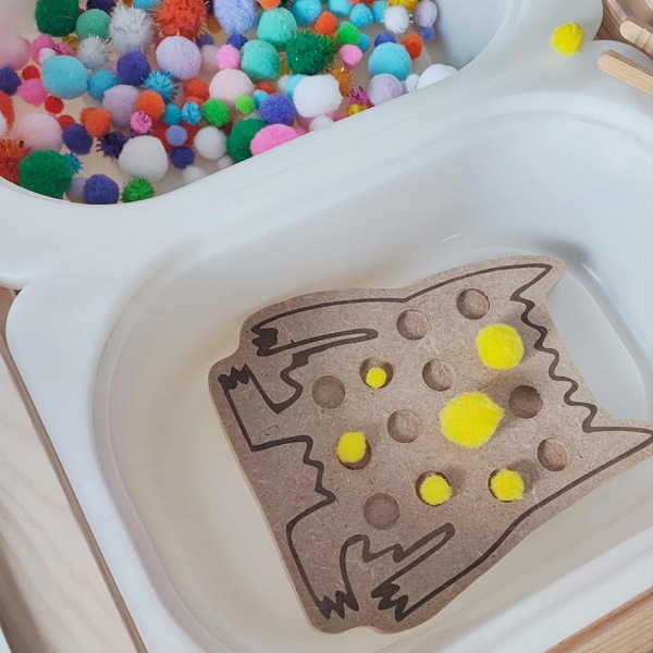 Jeu éducatif sensoriel avec support en bois monstre et pompons jaunes pour développer la motricité fine