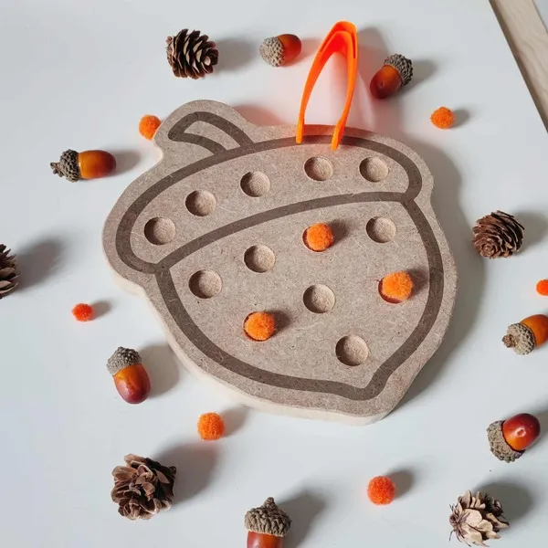 Plateau sensoriel en bois en forme de gland avec pompons orange et pince pour activités Montessori d’automne