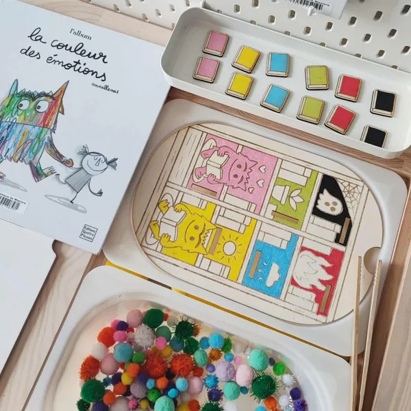 Activité sensorielle en bois inspirée du livre “La couleur des émotions” avec livres colorés à associer et pompons tactiles