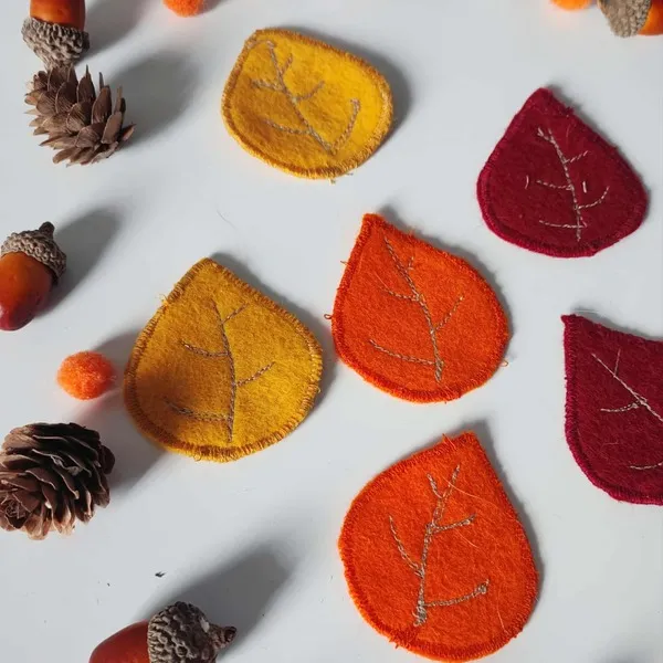 Feuilles en feutrine rouges, oranges et jaunes cousues main pour activité sensorielle d’automne