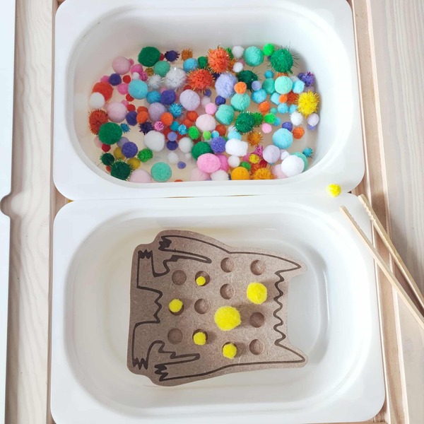 Atelier sensoriel Montessori avec support en bois et pompons colorés pour motricité fine