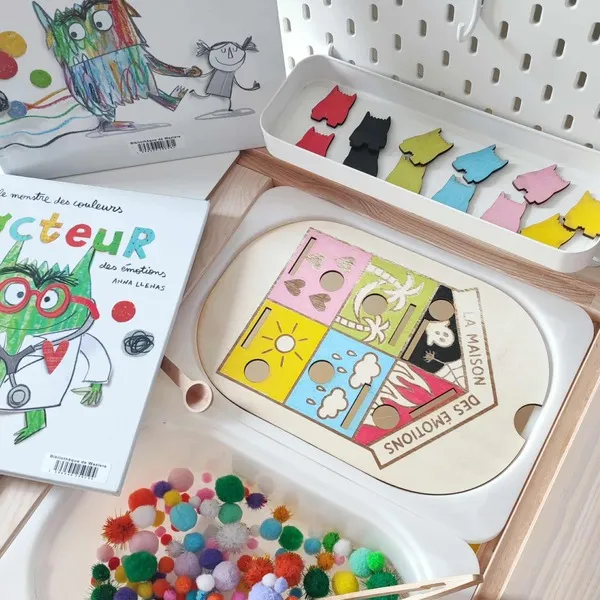 Jeu éducatif en bois “La maison des émotions” accompagné du livre “Le monstre des couleurs” et de pompons sensoriels colorés