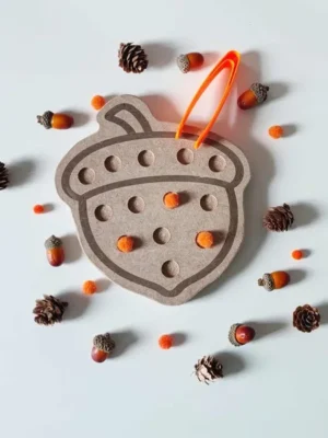 Plateau en bois en forme de gland avec pompons orange et pince pour activité sensorielle Montessori d’automne