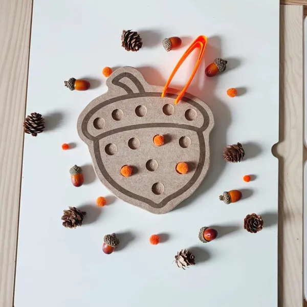 Plateau en bois en forme de gland avec pompons orange et pince pour activité sensorielle Montessori d’automne