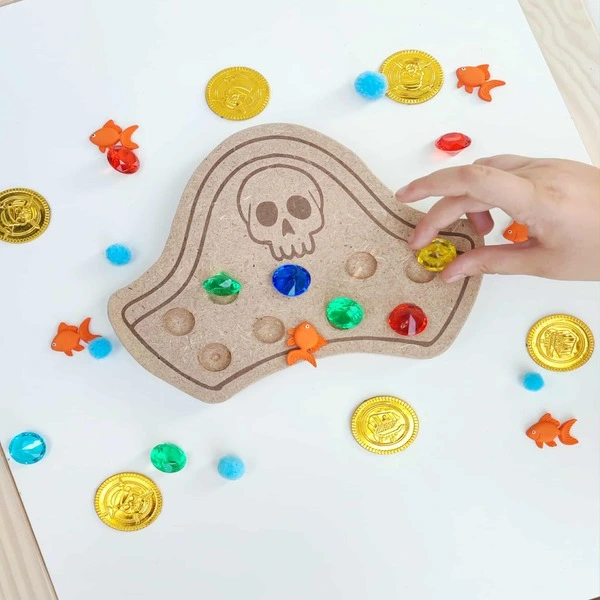 Enfant jouant avec un chapeau de pirate en bois rempli de pierres précieuses colorées