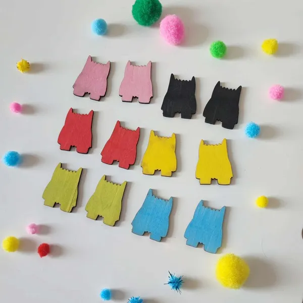 Jetons en bois colorés en forme de monstres disposés sur une table pour jeux éducatifs et activités sensorielles