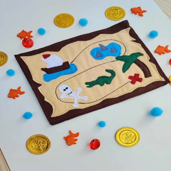 Carte au trésor en feutrine entourée de pièces d’or, poissons et gemmes – activité pirate pour enfants