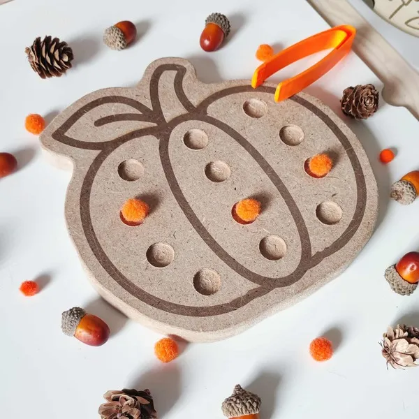 Activité Montessori d’automne avec plateau sensoriel citrouille en bois et pompons oranges