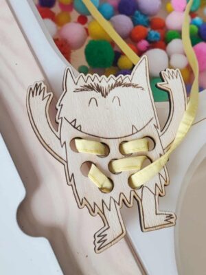 Activité Montessori carte à lacer en bois monstre avec lacet jaune pour développer la motricité fine