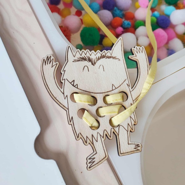 Activité Montessori carte à lacer en bois monstre avec lacet jaune pour développer la motricité fine