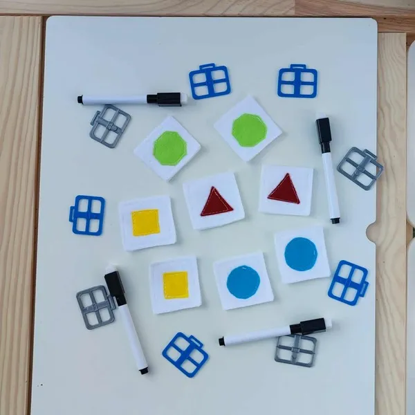 Cartes géométriques en feutrine colorée utilisées pour une activité sensorielle Montessori
