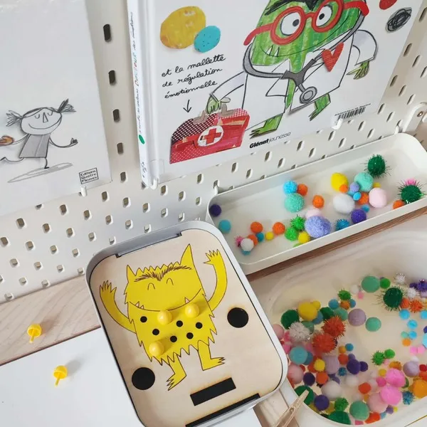 Atelier sensoriel sur les émotions avec support en bois monstre de la joie et pompons colorés