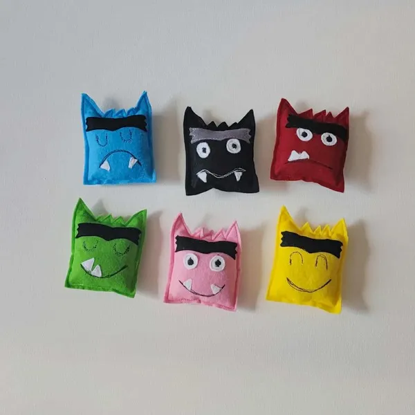 Petits coussins en feutrine colorés représentant des monstres aux différentes émotions pour activités éducatives