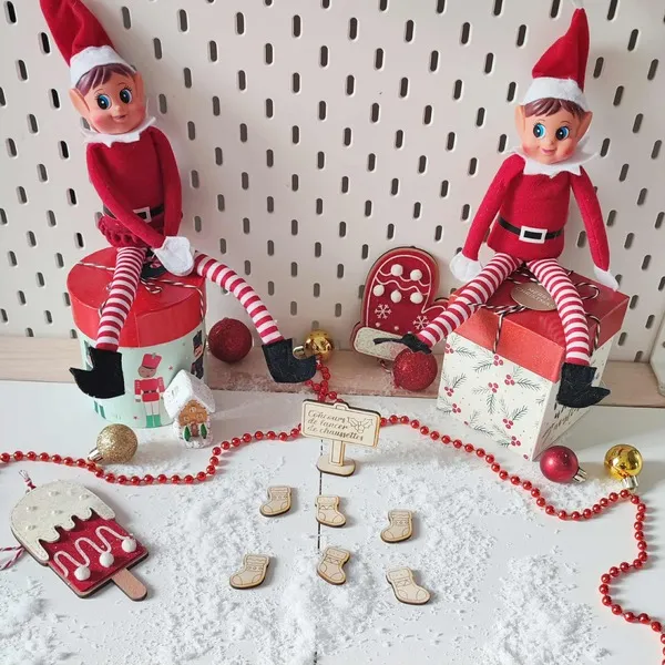 Lutins farceurs assis dans un décor de Noël jouant au concours de lancer de chaussettes en bois sur fond enneigé