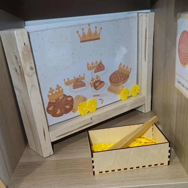 Fenêtre sensorielle en bois sur le thème de la galette des rois avec jetons jaunes et boîte de manipulation
