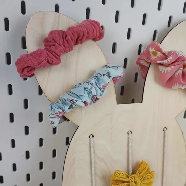 Détail du support mural en bois en forme de lapin avec chouchous colorés