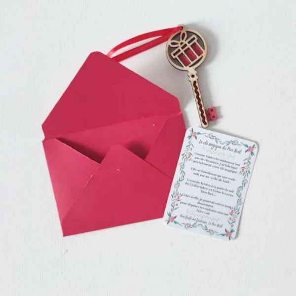 Clé magique du Père Noël en bois motif cadeau rouge avec carte explicative et enveloppe rouge sur fond clair