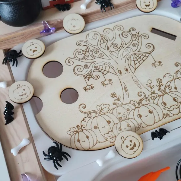 Zoom sur plaque sensorielle en bois gravée avec arbre décoratif, toiles d’araignée et citrouilles souriantes pour activité Halloween