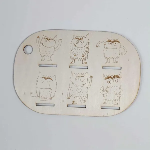 Plaque en bois gravée représentant les monstres des émotions inspirés du livre Le monstre des couleurs