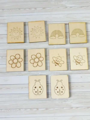 Jeu de mémoire en bois gravé sur le thème du printemps avec soleil, arc-en-ciel, fleurs, abeilles et coccinelles