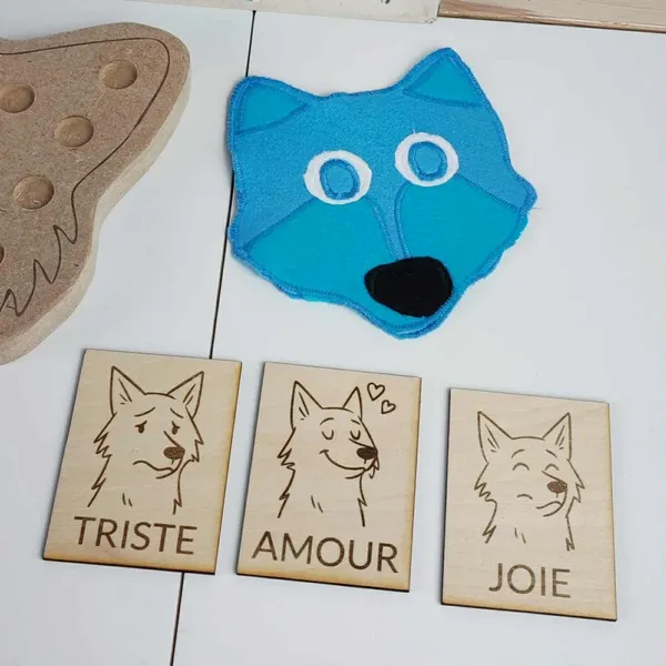Cartes en bois éducatives représentant les émotions du loup : tristesse, amour et joie, accompagnées d’un masque en feutrine bleue