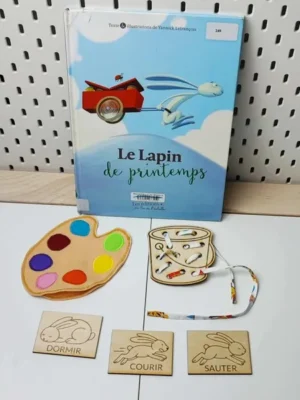Activité éducative inspirée du livre “Le Lapin de printemps” avec cartes en bois illustrant les verbes d’action et jeux sensoriels