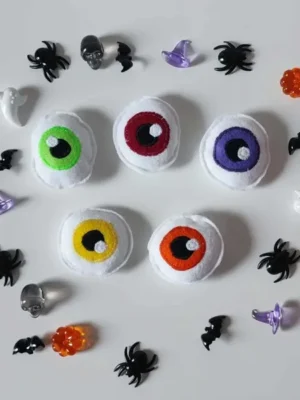 Jeu sensoriel d’Halloween en feutrine représentant des yeux colorés entourés de petites décorations effrayantes