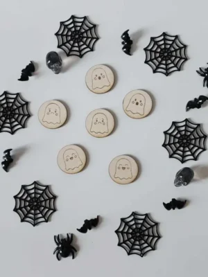 Jetons en bois fantômes pour activités Halloween sur fond décoré de toiles d’araignées et chauves-souris