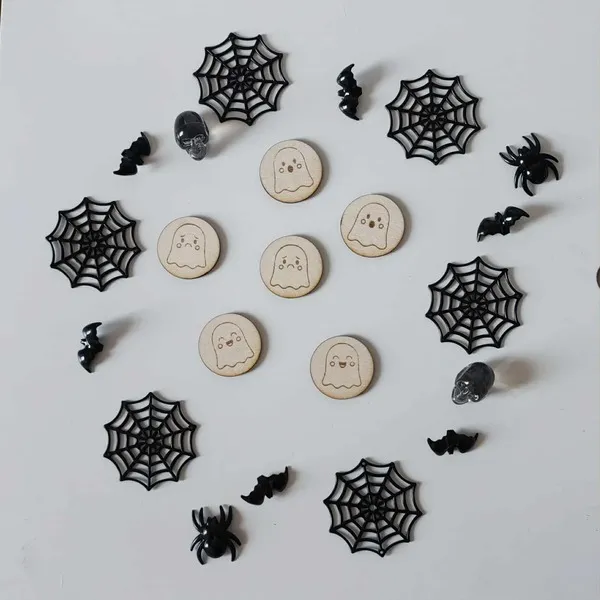 Jetons en bois fantômes pour activités Halloween sur fond décoré de toiles d’araignées et chauves-souris