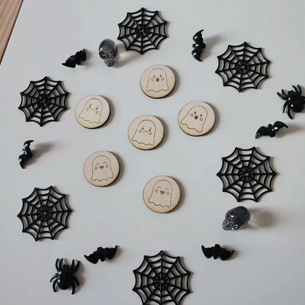 Jetons fantômes en bois pour activités d’Halloween entourés de décorations effrayantes