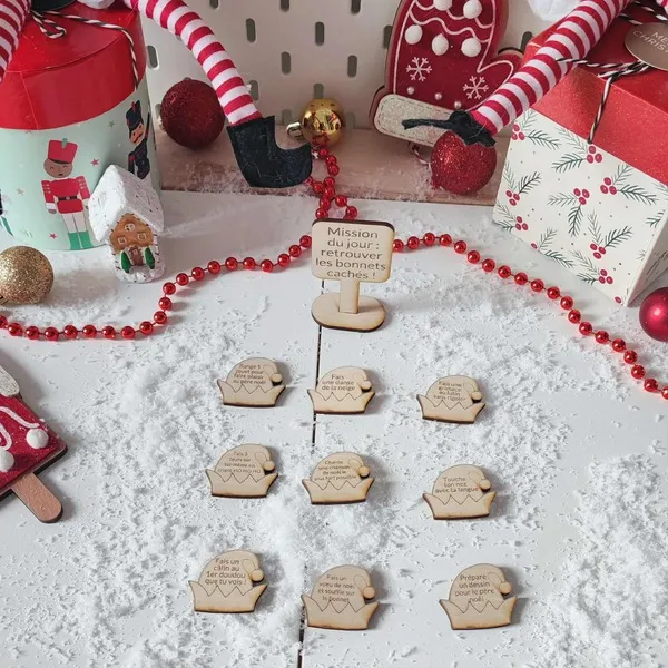 Jeu en bois Mission du jour retrouver les bonnets cachés présenté dans un décor de Noël enneigé avec lutins farceurs et accessoires festifs