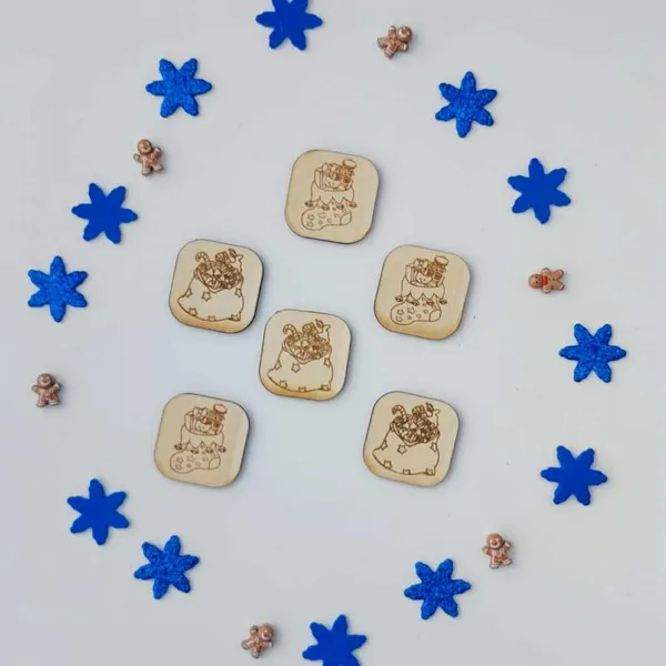 Jetons en bois gravés représentant la hotte du Père Noël remplie de jouets, entourés de flocons bleus et de petits sujets décoratifs de Noël