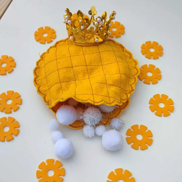 Galette des rois en feutrine jaune garnie de pompons blancs et surmontée d’une petite couronne dorée pour activité sensorielle Montessori
