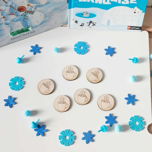 Jetons en bois gravés de tasses fumantes entourés de flocons bleus et pompons d’hiver pour activité sensorielle Montessori