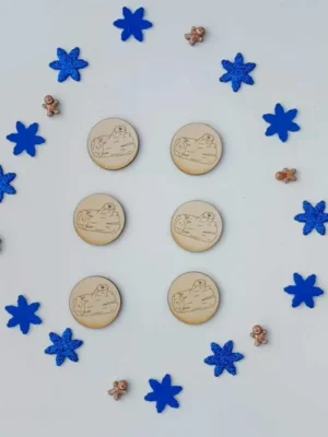 Jetons ronds en bois gravés représentant des bûches de Noël entourés de flocons bleus et de petits personnages pain d’épice – activité sensorielle hiver