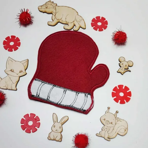 Moufle en feutrine rouge entourée d’animaux en bois du conte La Moufle et d’accessoires sensoriels rouges.