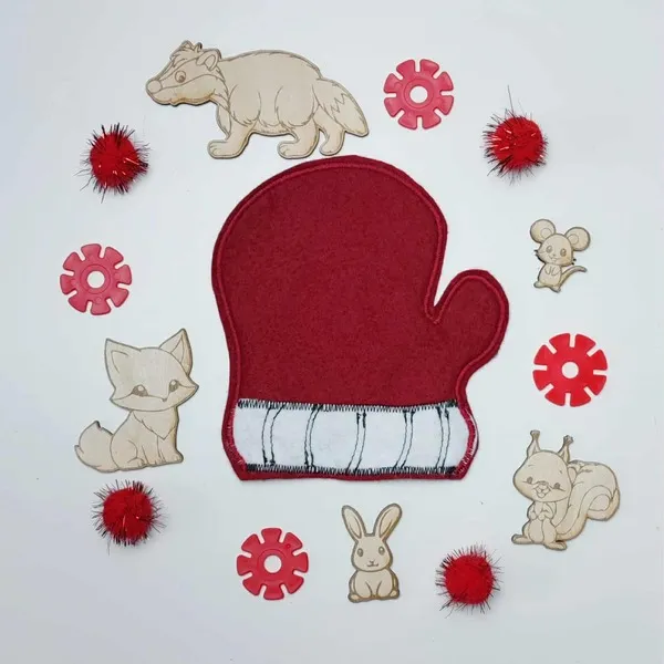 Moufle rouge en feutrine entourée d’animaux en bois du conte La Moufle et d’éléments décoratifs rouges.