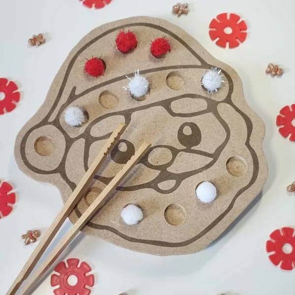 Plateau de motricité fine en bois représentant le visage du Père Noël avec pompons rouges et blancs et baguettes en bois, activité Montessori de Noël