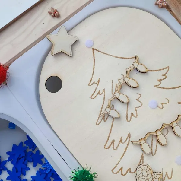 Détail d’un plateau en bois gravé représentant un sapin de Noël avec guirlande lumineuse amovible et étoile décorative Montessori