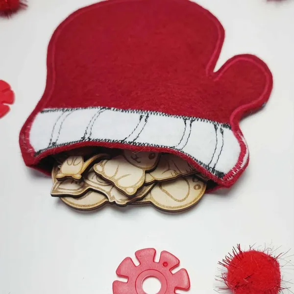 Moufle en feutrine rouge remplie de figurines en bois inspirées du conte La Moufle.