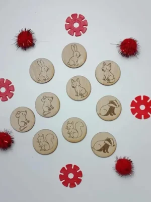 Jetons en bois illustrés d’animaux du conte La Moufle, disposés en cercle avec accessoires rouges.