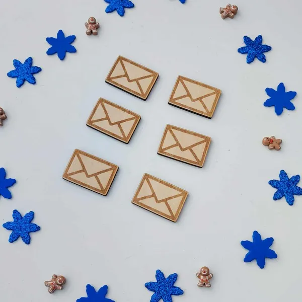 Six petites enveloppes en bois gravées, entourées de flocons bleus et de mini bonshommes pain d’épices, accessoires artisanaux du plateau facteur du Père Noël
