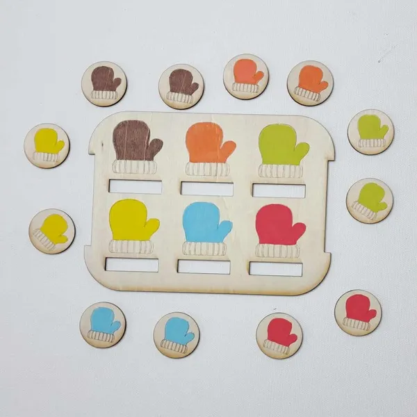 Plateau de tri en bois avec des moufles colorées et jetons assortis disposés tout autour.