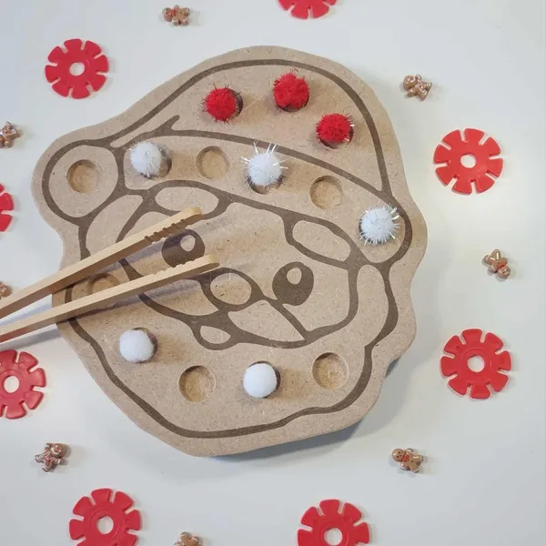 Activité Montessori de motricité fine avec plateau en bois en forme de Père Noël, pompons rouges et blancs et baguettes d’apprentissage pour enfants