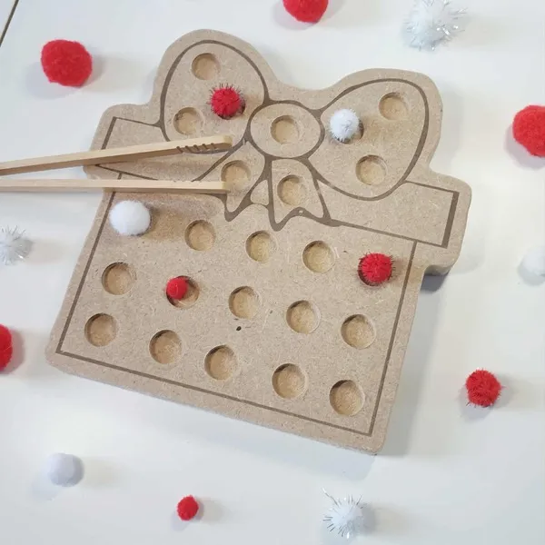 Plateau de motricité fine en bois MDF en forme de cadeau de Noël, décoré d’un grand nœud et utilisé avec des pompons rouges et blancs et des baguettes en bois