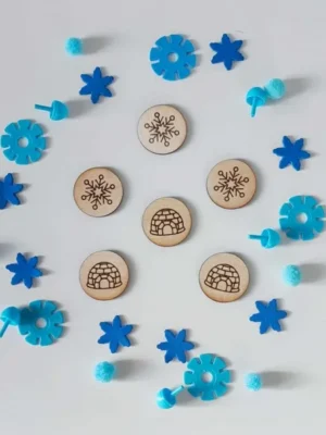 Jetons en bois gravés igloo et flocon entourés de pompons bleus et flocons décoratifs pour activité sensorielle banquise