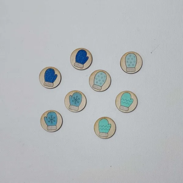 Jetons en bois représentant des moufles bleues disposés pour une activité d’association hivernale.