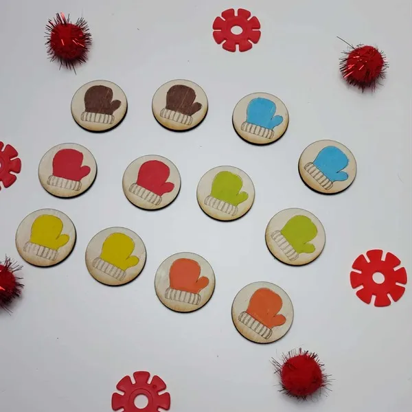 Jetons en bois en forme de moufles colorées, disposés en cercle avec des accessoires sensoriels rouges sur fond blanc.