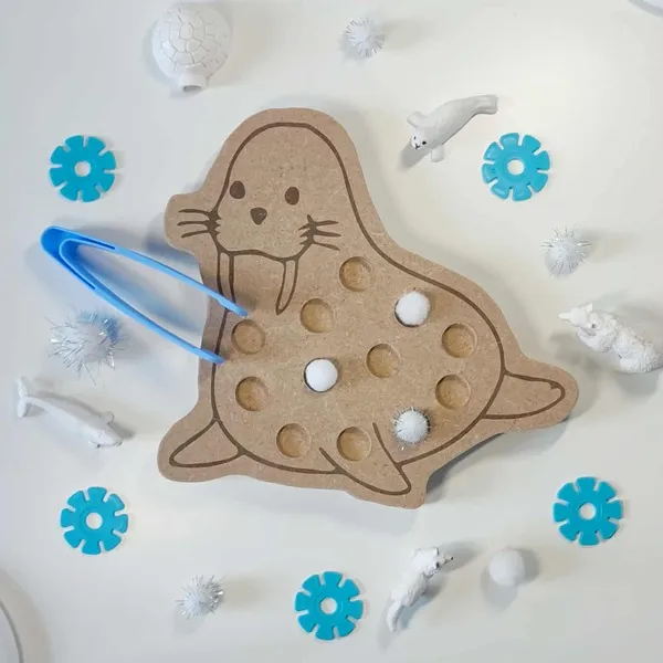Plateau de motricité fine en bois en forme de morse avec pompons blancs et pince bleue, activité sensorielle Montessori sur le thème de la banquise