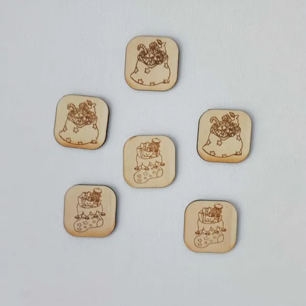 etons en bois carrés gravés au laser représentant la hotte du Père Noël remplie de jouets et de bonbons, disposés sur fond clair